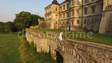 鸟瞰：古色古香的城堡背景上美丽的婚礼情侣.. 4k